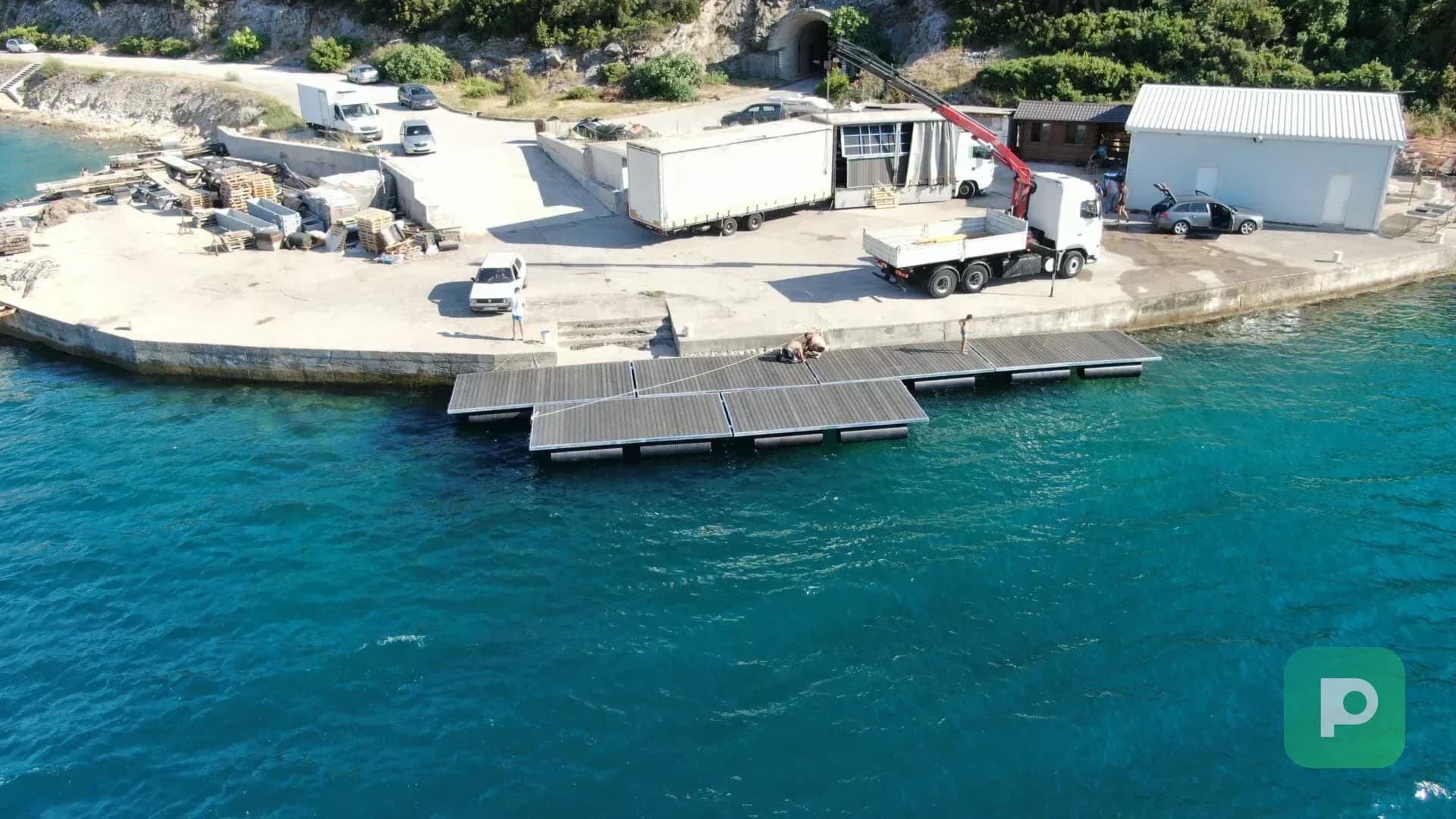 Modularna plutajuća marina u fazi montaže na moru, sa PEHD pontonima, radnom platformom i obalnim pristupom.