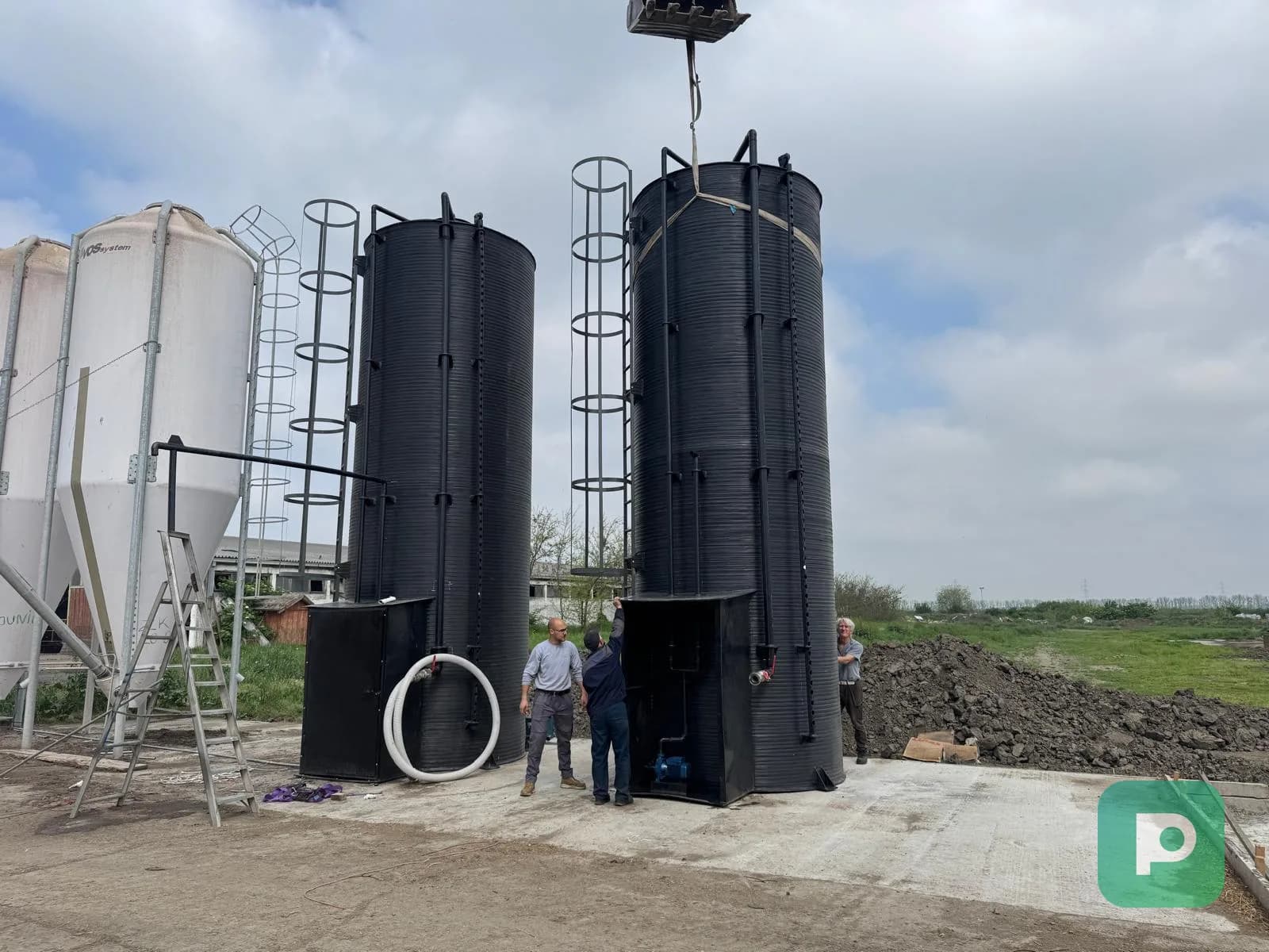 Large vertical Plastopex industrial tanks with access ladders during on-site installation